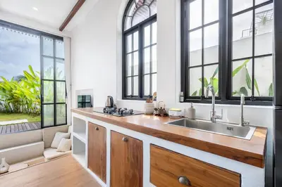 a kitchen with a sink and large windows at Palm Sugar Villa - Stylish 3BR Retreat with Pool in Jimbaran