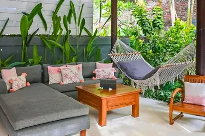 a hammock in a living room with a couch and a table at Indira Peaceful 1 BR Private Pool Villa in Seminyak