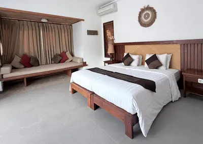 a bedroom with a large bed and a couch at Alex Villa Bali in Seminyak
