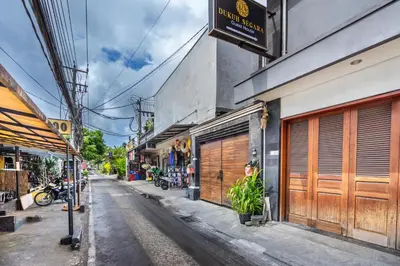 an empty street in an alley with buildings at Collection O Dukuh Segara Guest House in Balian