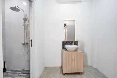a bathroom with a sink and a mirror at Collection O Dukuh Segara Guest House in Balian