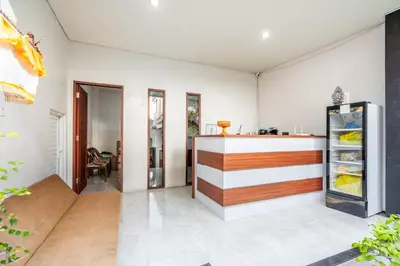 a kitchen with a counter and a refrigerator at Collection O Dukuh Segara Guest House in Balian