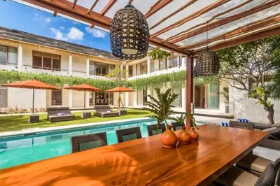 a dining room with a table and a swimming pool at Kalyca Stunning 5 BR Private Pool Villa in Jimbaran