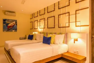 a bedroom with two beds and a painting on the wall at Kalyca Stunning 5 BR Private Pool Villa in Jimbaran