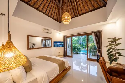 a bedroom with a bed and a large window at Villa Melbourne in Seminyak