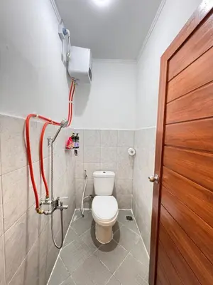 a bathroom with a toilet and a shower at Cozy Minimalist Home Near Seminyak & Kuta in Seminyak
