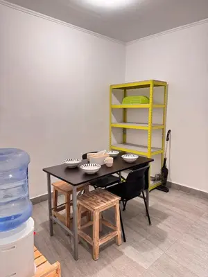 a room with a table and chairs and a yellow shelf at Cozy Minimalist Home Near Seminyak & Kuta in Seminyak