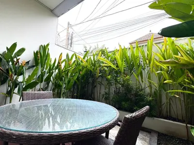 a patio with a table and chairs and plants at Jalina Private Villa in Central Seminyak in Seminyak