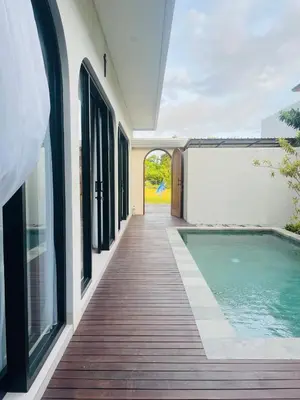 a house with a swimming pool next to a building at Brand new central Villa in Canggu