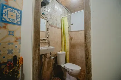 a small bathroom with a toilet and a sink at Samblung Mas House in Denpasar