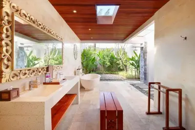 a bathroom with a large tub and a large window at Deanda Elegant 4 BR Private Pool Villa in Jimbaran