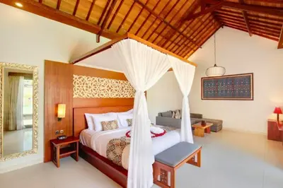 a bedroom with a bed with a canopy at Eksha Comfortable 3 BR Private Pool Villa in Jimbaran