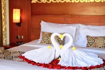 two white swans making a heart on a bed at Eksha Comfortable 3 BR Private Pool Villa in Jimbaran
