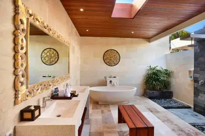 a bathroom with a tub and a large mirror at Eksha Comfortable 3 BR Private Pool Villa in Jimbaran