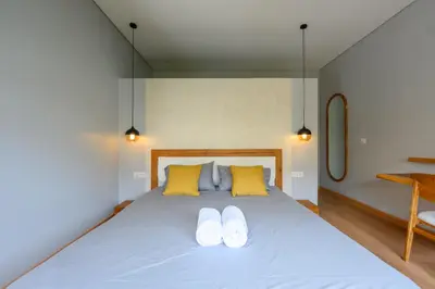 a bedroom with a bed with yellow and white pillows at Spacious 4BR Family Pool Villa in Sanur