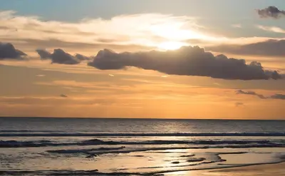 a sunset on the beach with the ocean at Wisp Sunset in Legian