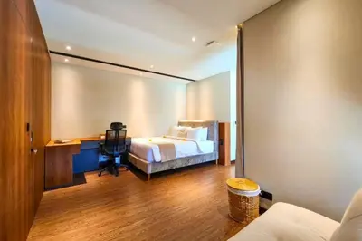 a bedroom with a bed and a desk in a room at Foujina Elegant 4 BR Private Pool Villa in Jimbaran