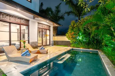 a villa with a swimming pool and a house at D'Maya Villa Jimbaran By Island Escape in Jimbaran