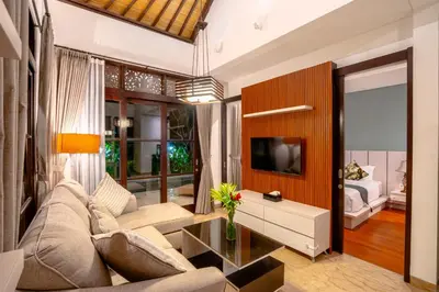 a living room with a couch and a tv at D'Maya Villa Jimbaran By Island Escape in Jimbaran