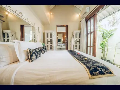 a large white bed in a room with a large window at Romantic getaway Seminyak in Seminyak