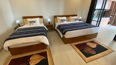 two beds in a room with two rugs at Narayuka private villa in Seminyak