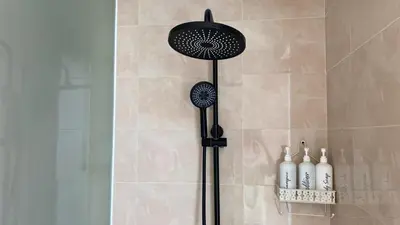 a shower with a black shower head in a bathroom at Narayuka private villa in Seminyak