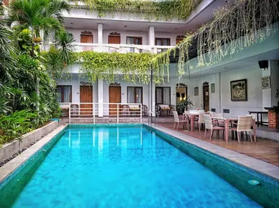a pool in a hotel with a table and chairs at Dlima Hotel Villa in Legian
