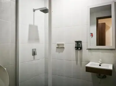 a bathroom with a shower with a sink and a mirror at Dlima Hotel Villa in Legian