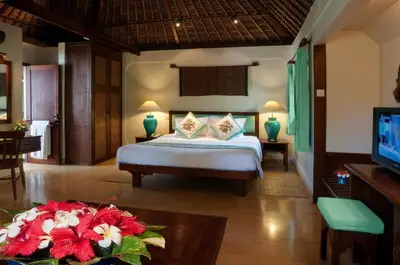 a bedroom with a bed and a tv in a room at Poppies Bali in Kuta