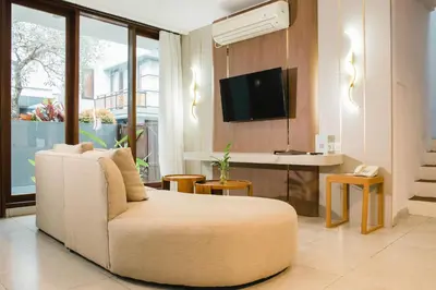 a living room with a couch and a flat screen tv at Grand Kesambi Resort and Villas Seminyak in Seminyak