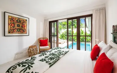 a bedroom with a bed and a view of a pool at Villa Atma 2BR Fully Equipped Kitchen in Seminyak