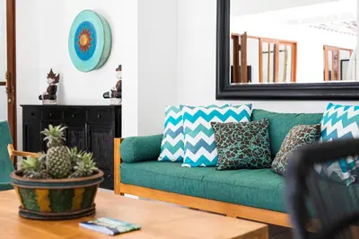 a living room with a green couch and a table at Villa Merah in Seminyak