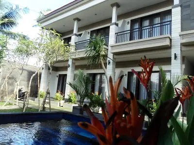 a house with a swimming pool in front of it at De Dukuh Guest House in Kuta