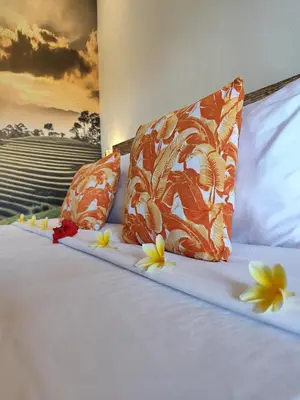 a bed with orange pillows and flowers on it at Villa Sammy in Seminyak