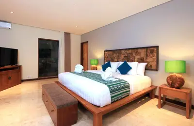 a bedroom with a bed with two teddy bears on it at Desa Di Bali Villas in Kerobokan