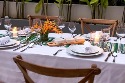 a table with plates and glasses and candles on it at Desa Di Bali Villas in Kerobokan