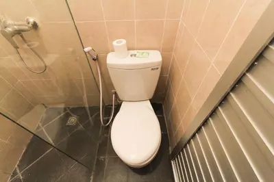 a bathroom with a toilet and a shower at Akatara Stay in Jimbaran
