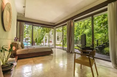 a bedroom with a bed and a large window at Villa Saba 10 in Seminyak