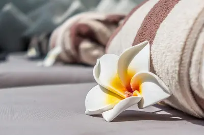 a close up of a white flower on a pillow at Villa Saba 10 in Seminyak