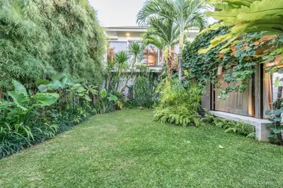 a garden with green plants and a building at Villa Saba 10 in Seminyak