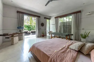 a bedroom with a large bed and a table at Villa Saba 10 in Seminyak