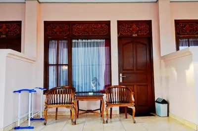 two chairs and a table in front of a door at Pesona Beach Inn in Kuta