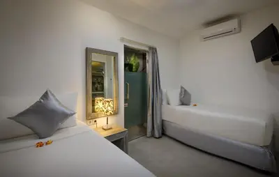 a white bedroom with a bed and a mirror at Villa Ozamiz Seminyak in Seminyak