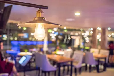 a light fixture in a restaurant with tables and chairs at Infinity8 Bali in Jimbaran