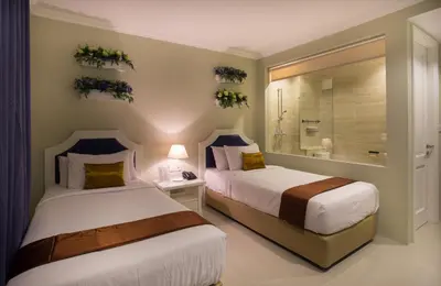 a bedroom with two beds and a shower in it at Amalfi Hotel Seminyak in Seminyak