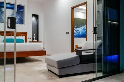 a bedroom with a bed and a chair and a mirror at Kamil Villas in Seminyak