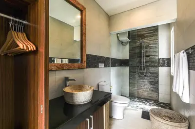 a bathroom with a sink and a toilet and a mirror at Puri Bagus Villa by Great Bali Villas in Legian