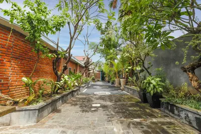 an alley with trees and a brick wall at Puri Bagus Villa by Great Bali Villas in Legian