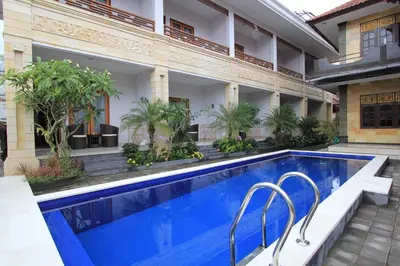 a swimming pool in front of a building with a hotel at The Kutaya in Kuta