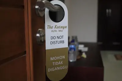 a door knob with a sign that says do not disturb at The Kutaya in Kuta